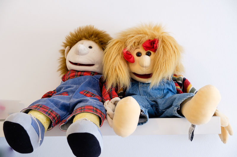 Therapiepuppen auf dem Regal im Praxisflur